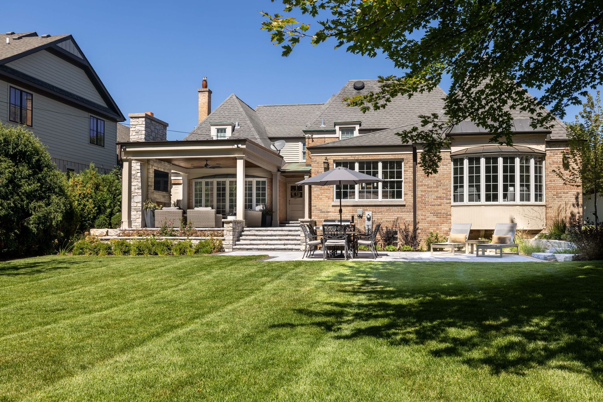 A large brick house with a large lawn in front of it