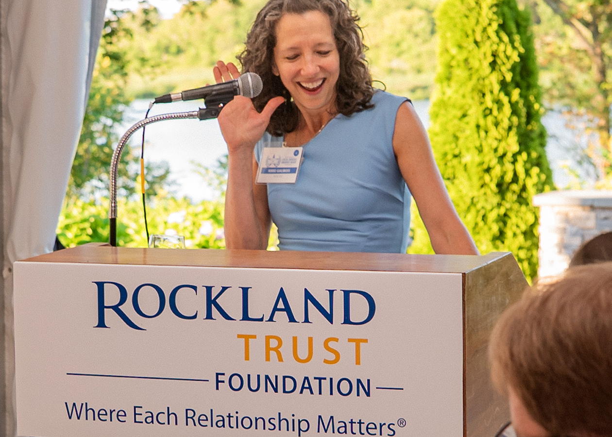 Woman speaking at a podium at an outdoor event