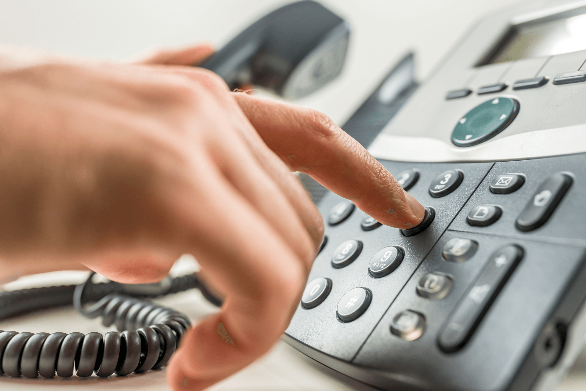 Consumer aid worker dialing an office phone