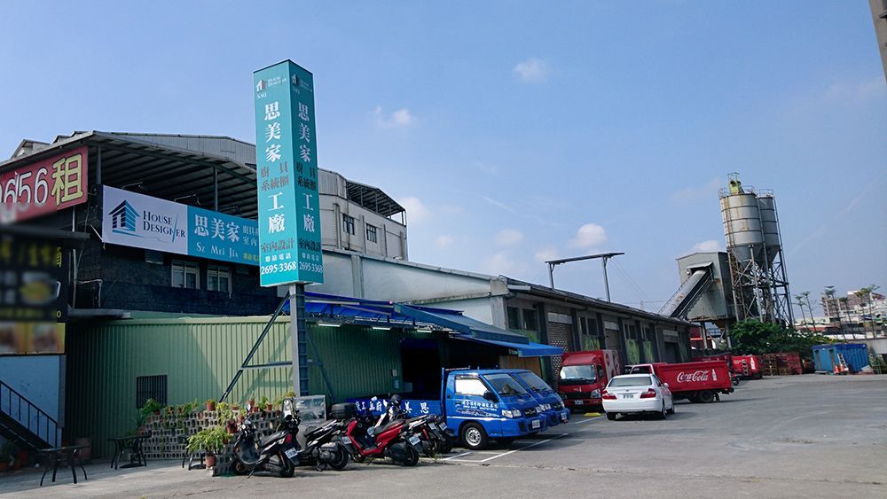 一排汽車和摩托車停在一棟大樓前。