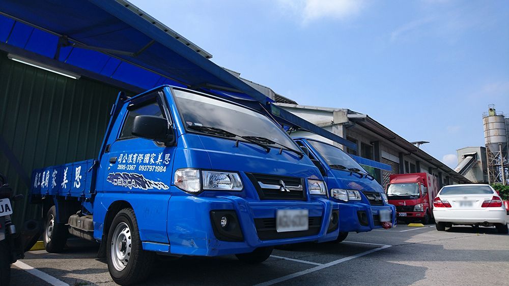一排藍色卡車停在停車場。