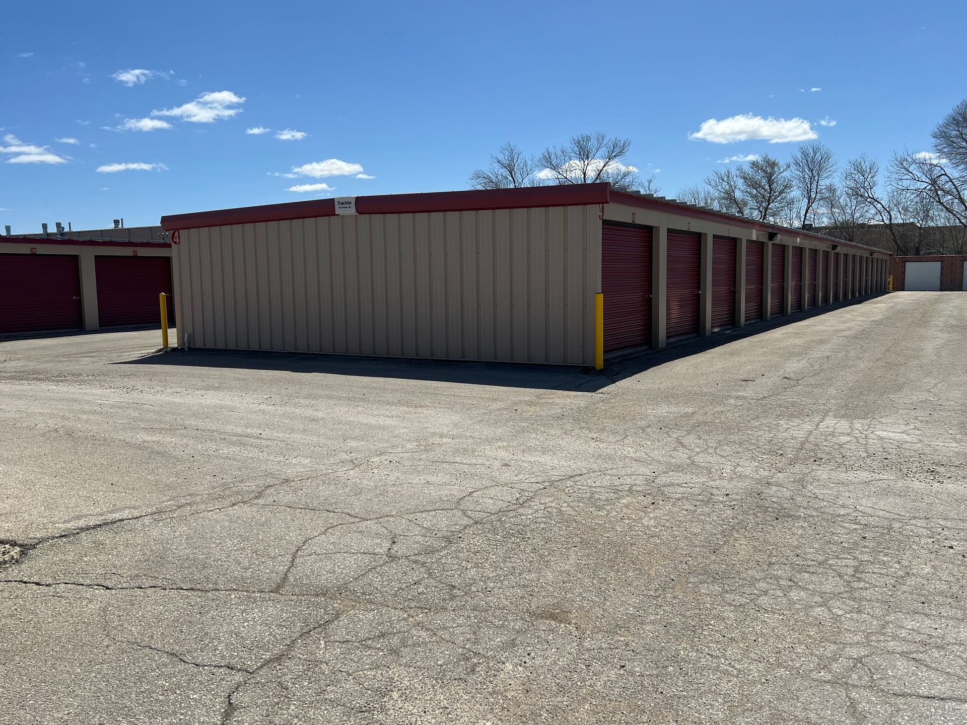 A Man is Holding a Cardboard Box in Front of a Storage Unit