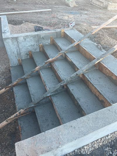 Concrete staircase under construction with wooden braces and formwork around the steps