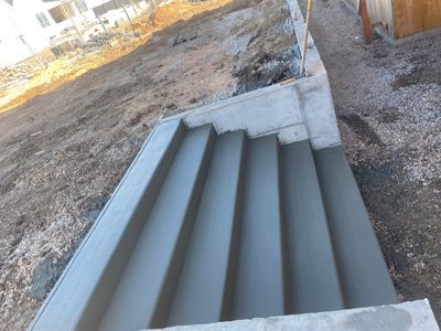 Gray metal stairway with concrete sides on a gravel construction site
