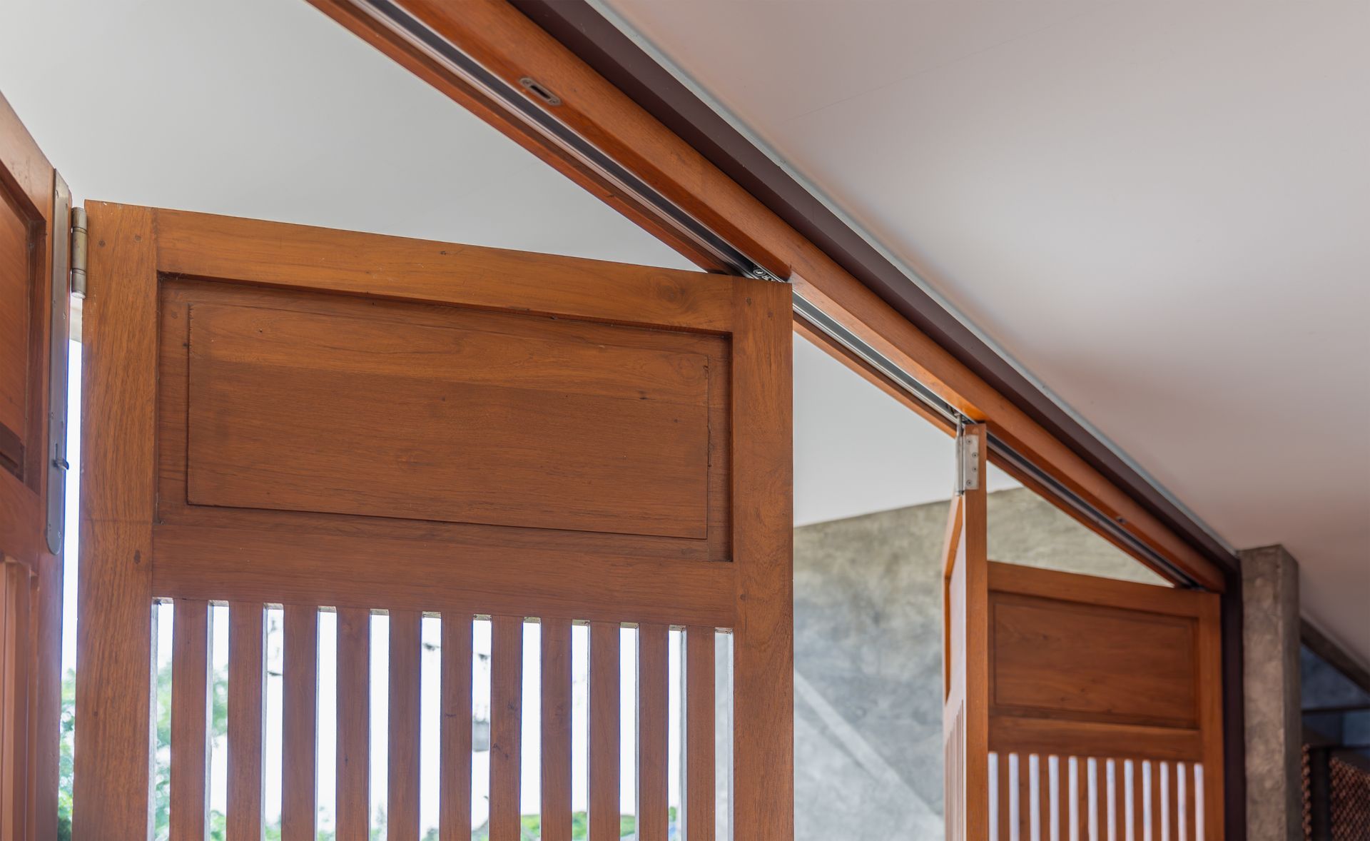 Wooden Slatted Gate Under a Sloped Ceiling Beside a Mirrored Wall Panel — Roo’s Door & Window Maintenance In Sippy Downs, QLD