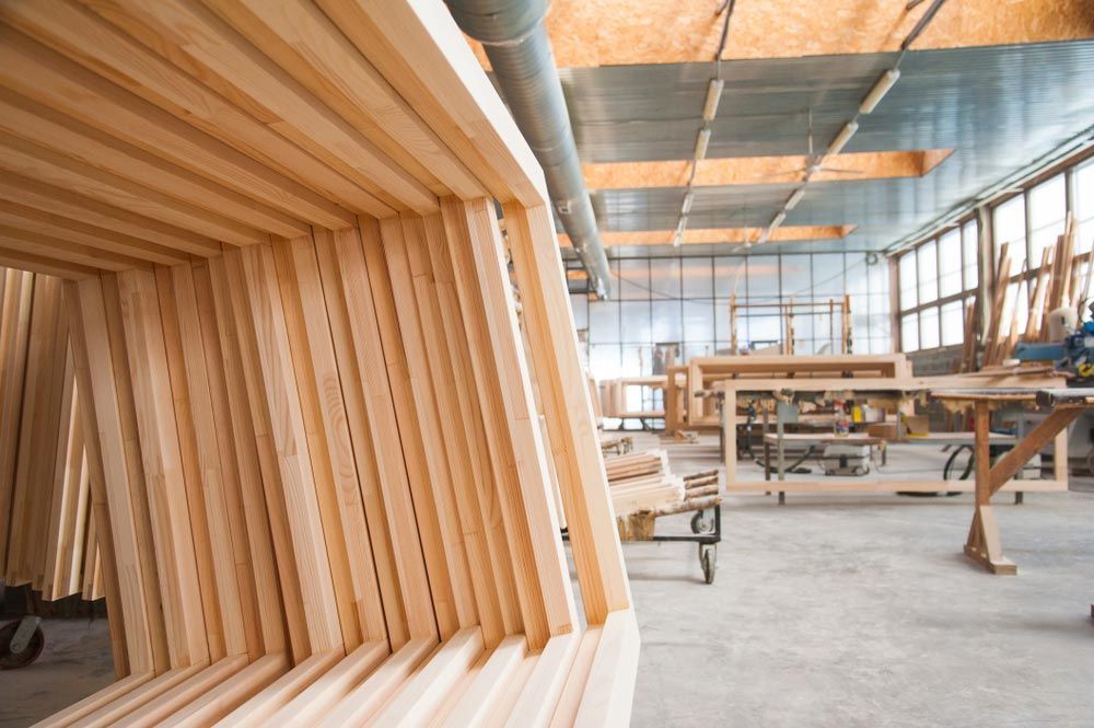 A Stack Of Wooden Frames In A Factory — Roo’s Door & Window Maintenance In Sippy Downs, QLD