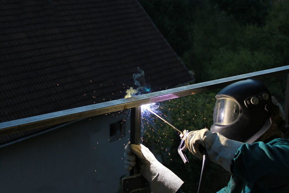 A Man Wearing a Welding Mask is Welding a Piece of Metal — Metaltrendz in Coolum Beach, QLD