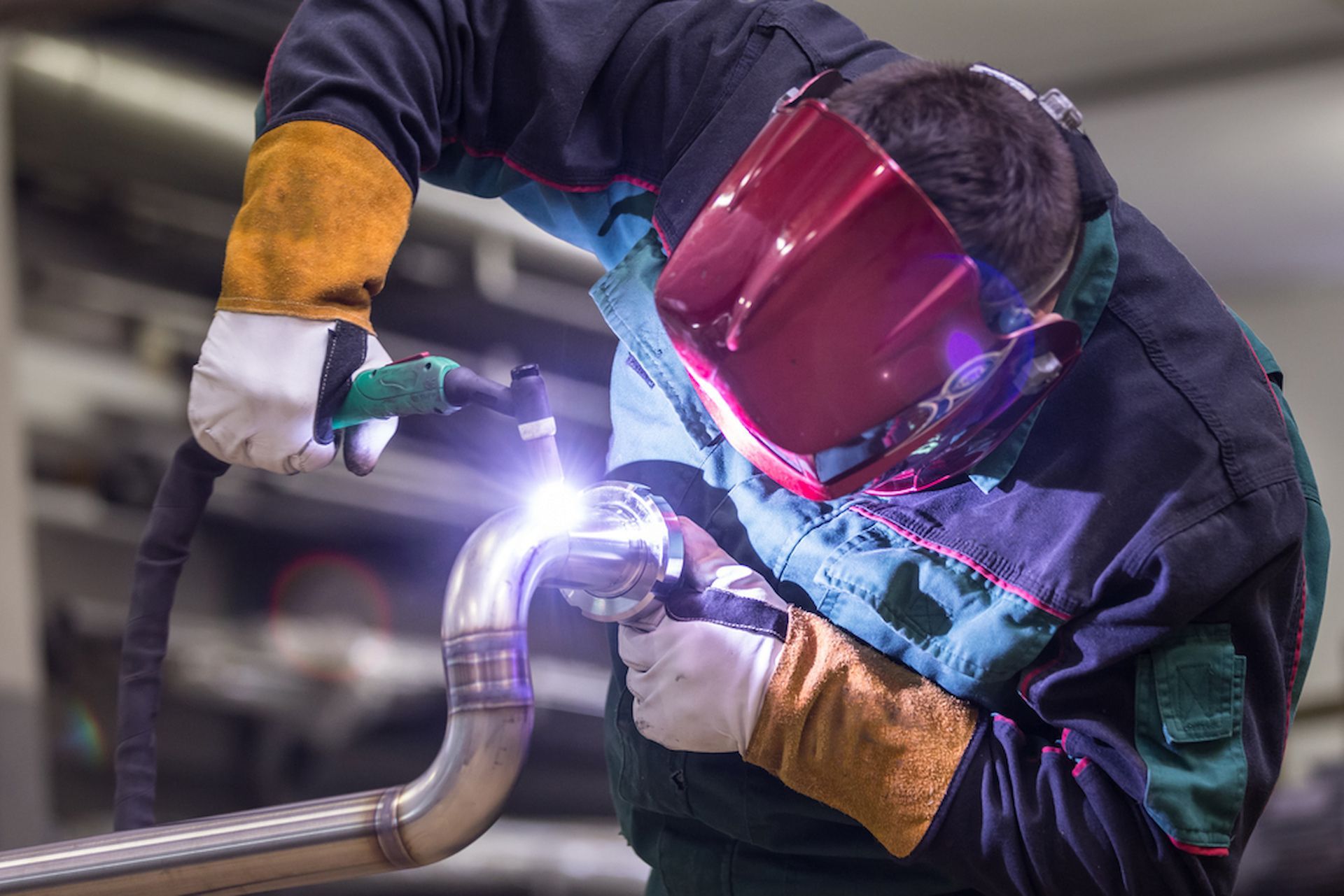 A Man Wearing a Welding Mask is Welding a Pipe — Metaltrendz in Kunda Park, QLD