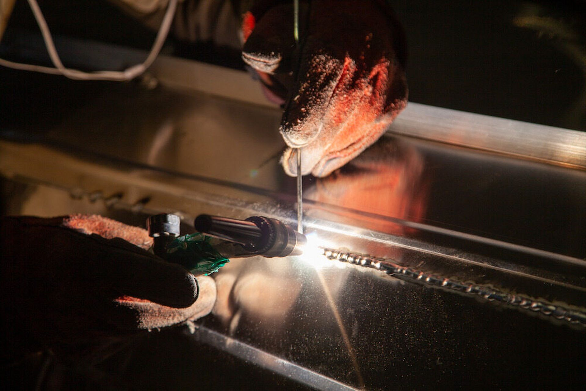A Person is Welding a Piece of Metal in a Dark Room — Metaltrendz in Coolum Beach, QLD