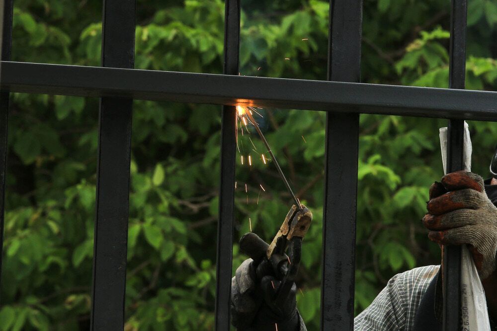 A Man is Welding a Metal Fence With a Torch — Metaltrendz in Kunda Park, QLD