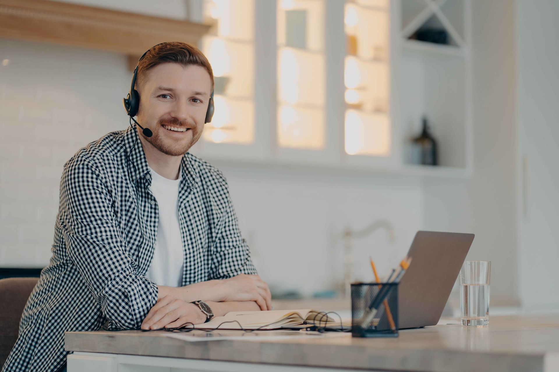 Cheerful guy enjoying freelance job while sitting at his workplace