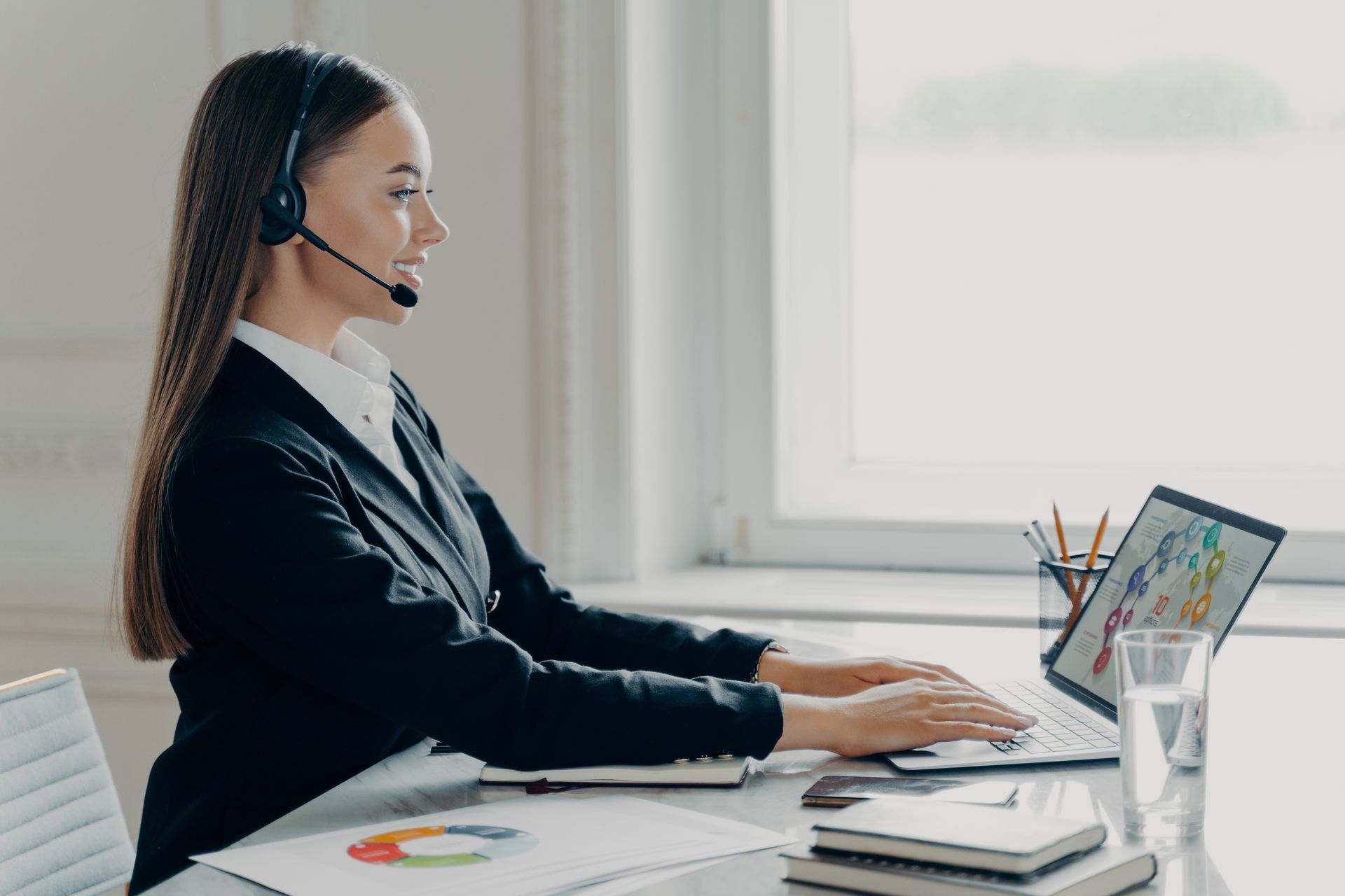 Professional business lady wearing headset working with financial data during online meeting