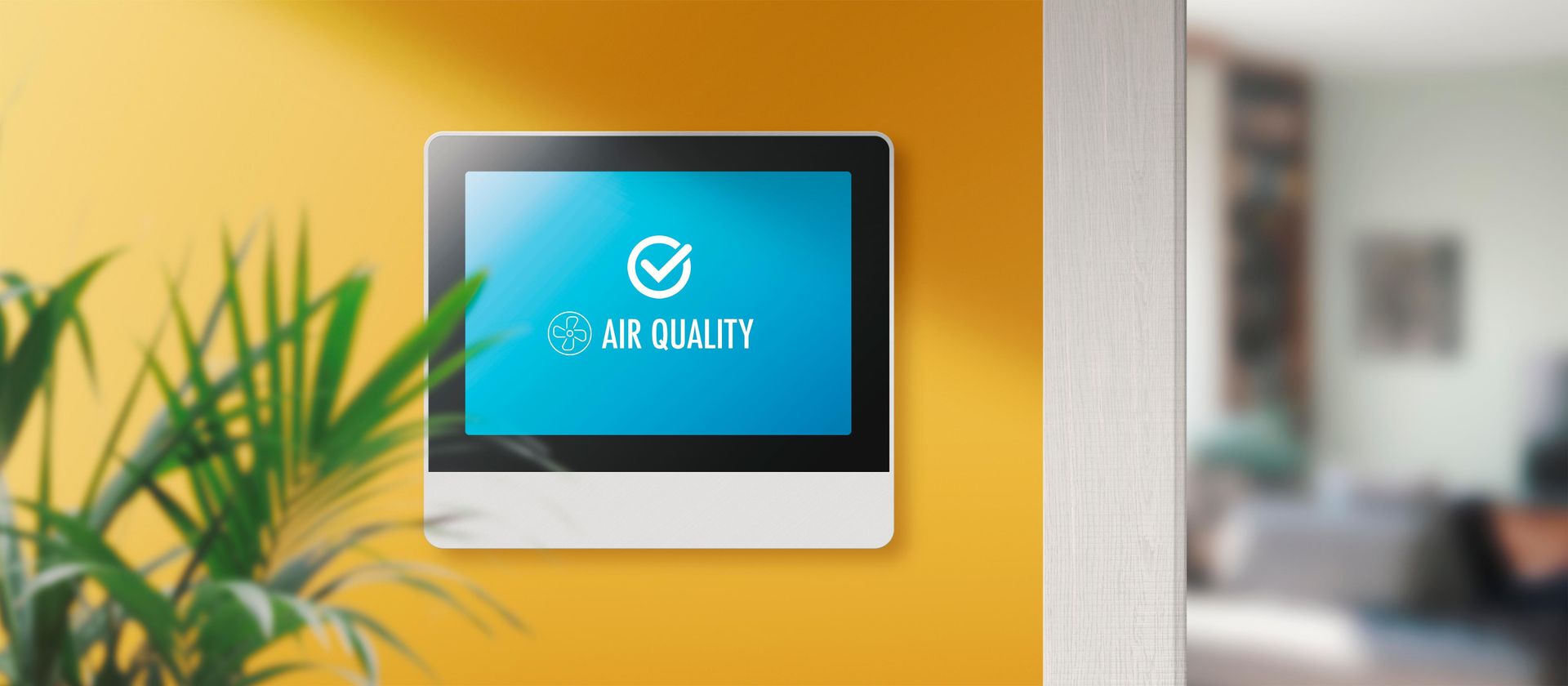 A wall-mounted air quality monitor with a blue screen. 