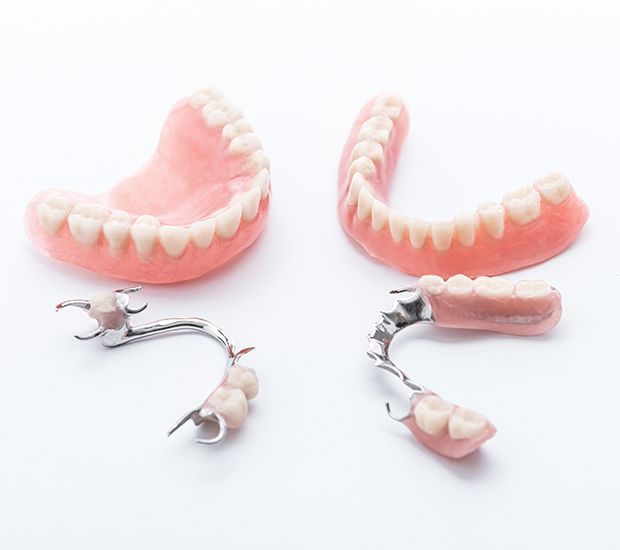 Dental prosthetic dentures and partial plates arranged on a white background