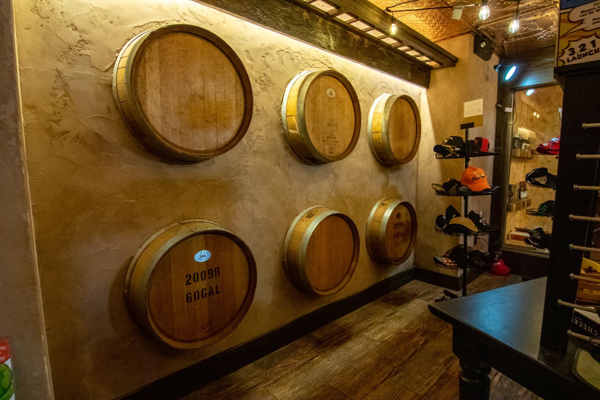 A row of wooden barrels hanging on a wall in a wine cellar.