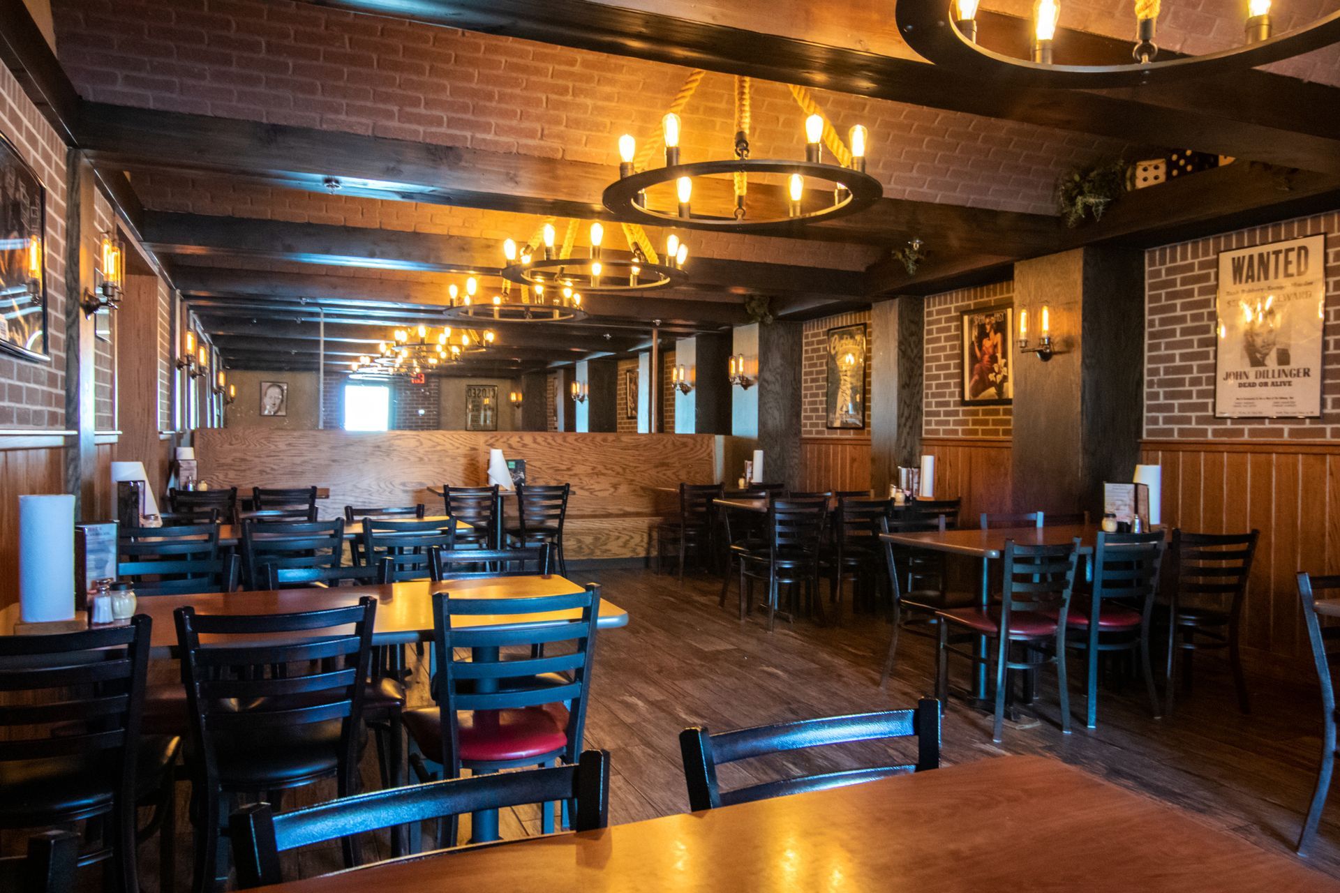 A restaurant with tables and chairs and a brick wall.