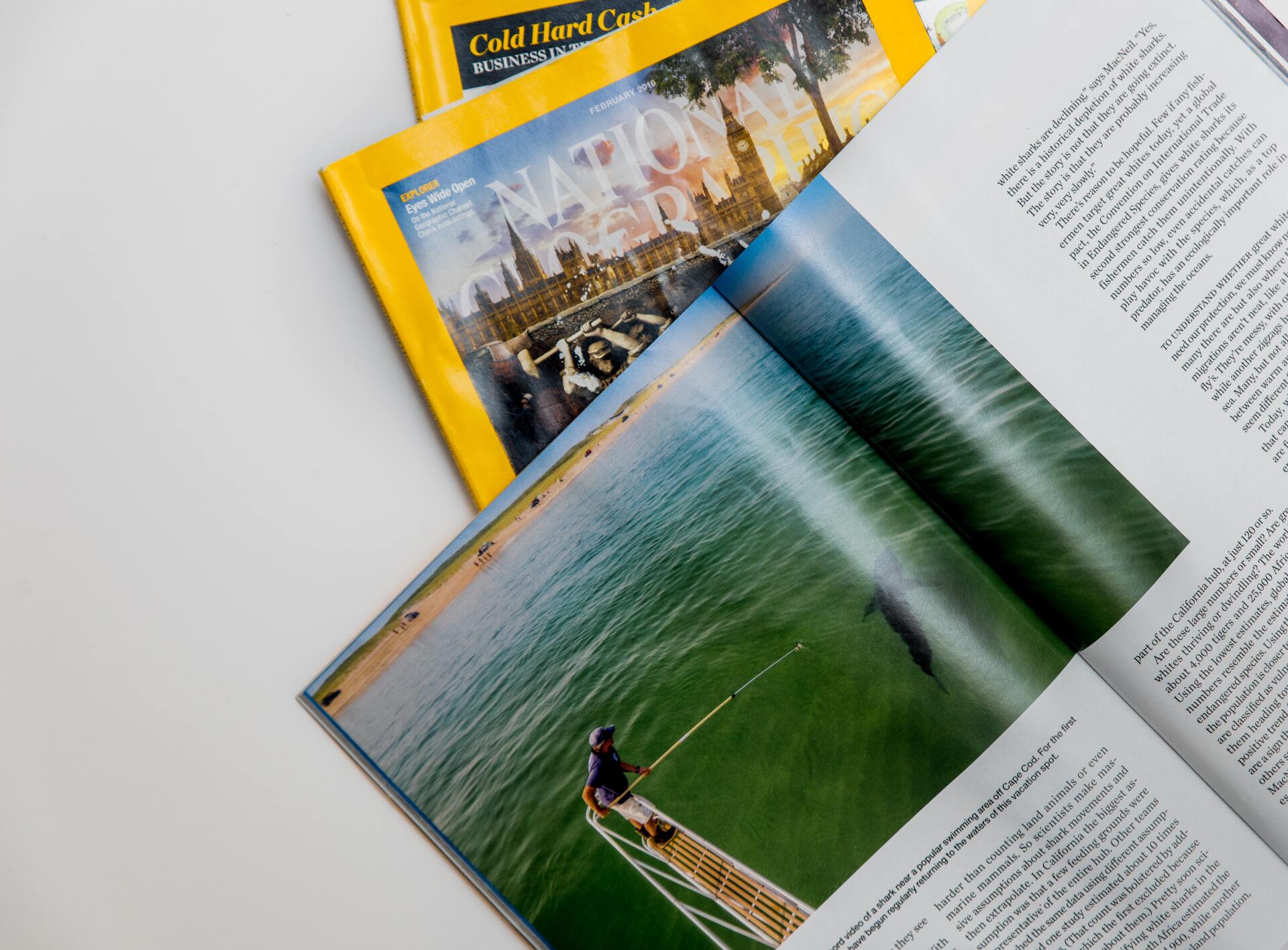 A magazine is open to a page with a picture of a person in a boat in the water.