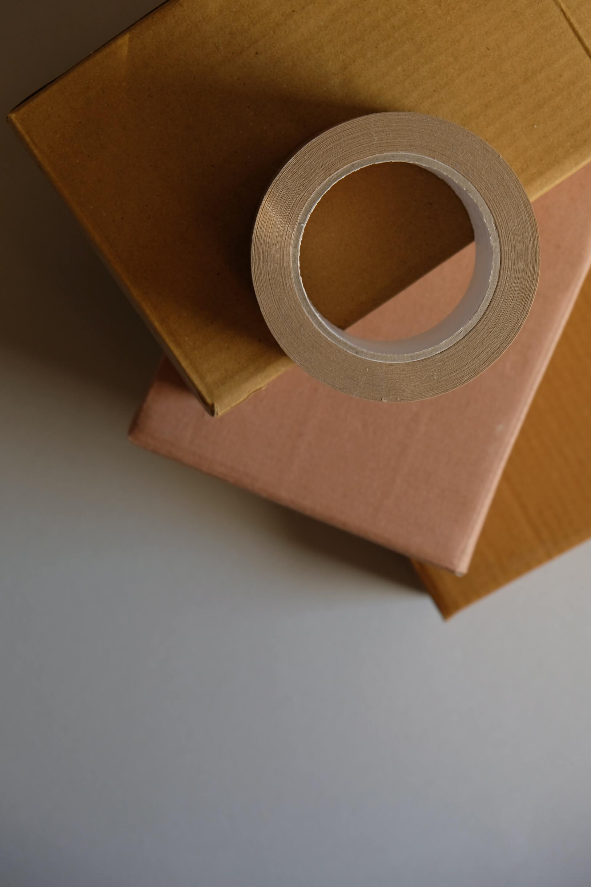 A roll of tape is sitting on top of a stack of boxes.