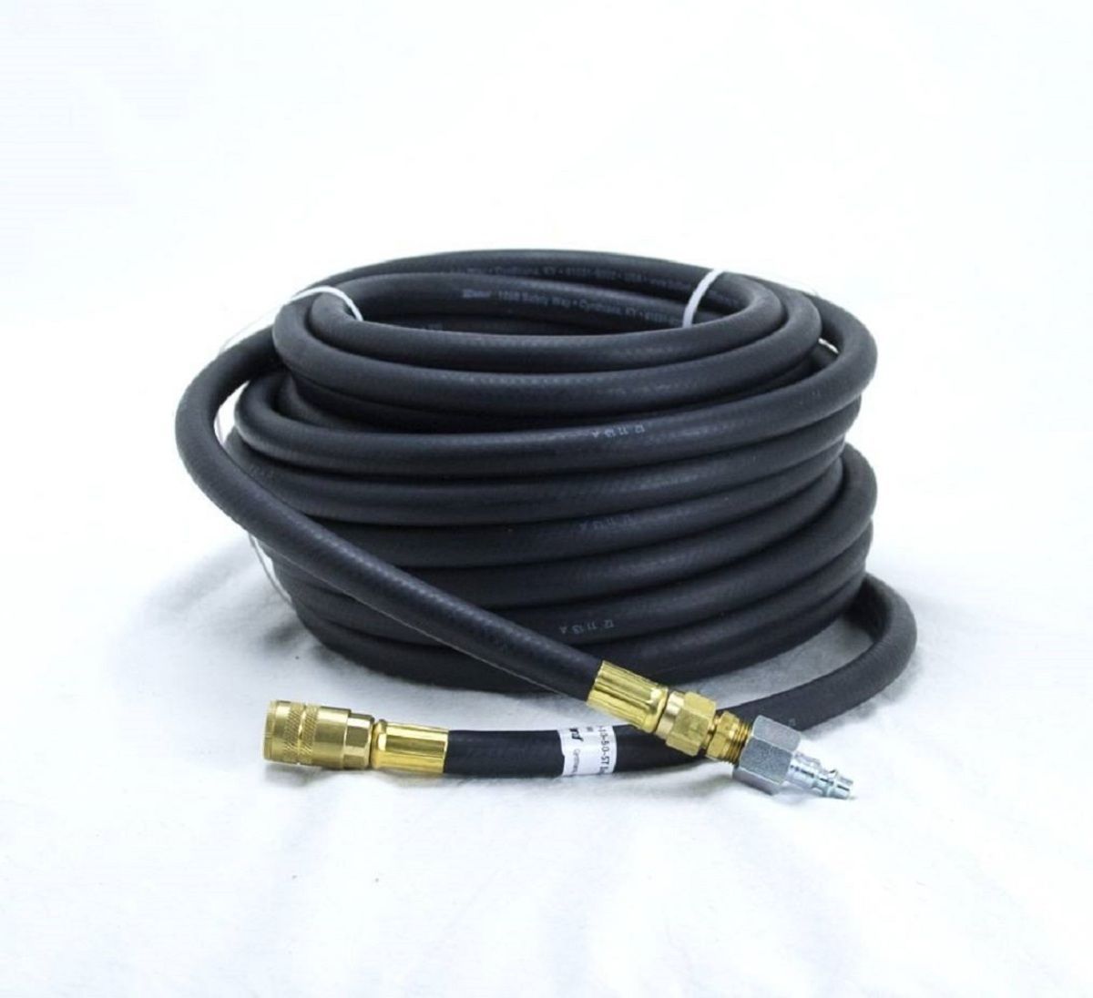 Coiled black hose with brass fittings on a white background