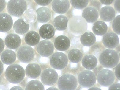 Close-up of translucent white and gray spherical beads packed together