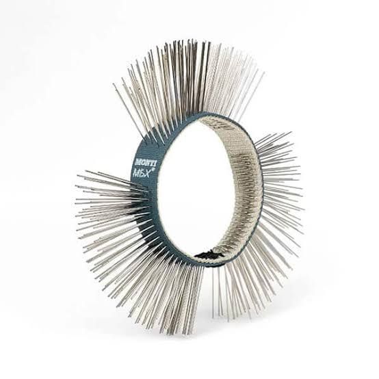 Circular metal brush with dense silver bristles around a ring-shaped center on a white background