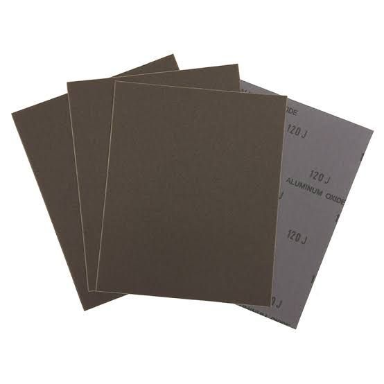 Stack of brown sandpaper sheets with one gray sheet on the right