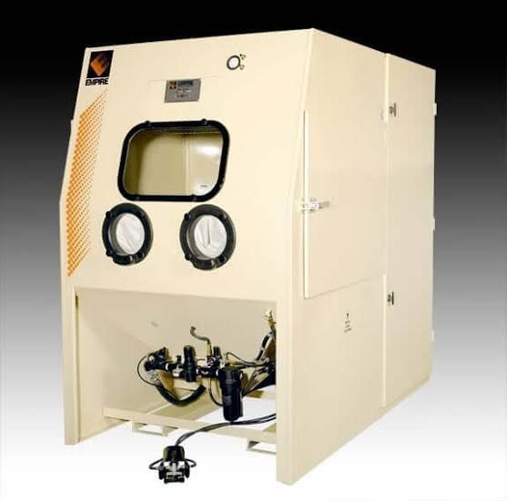 Beige industrial glovebox chamber with view window and attached hoses on a white background