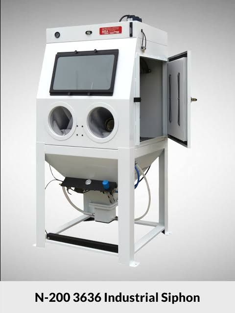 White industrial siphon machine with viewing window, round glove ports, and side cabinet on a metal stand