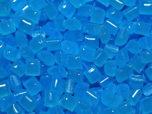 Close-up of small bright blue translucent beads scattered together.