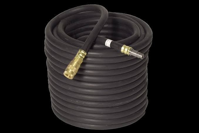 Coiled black hose or cable with brass connectors on a black background