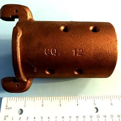 Copper cylindrical metal part with mounting tabs, marked