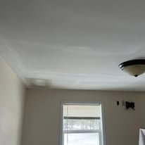 White ceiling in a room with a window and a ceiling light fixture
