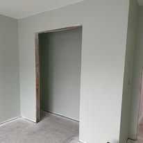 Empty doorway in a light gray room with white trim and tiled floor