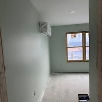 Empty room with light gray walls, a window, and tiled floor under construction