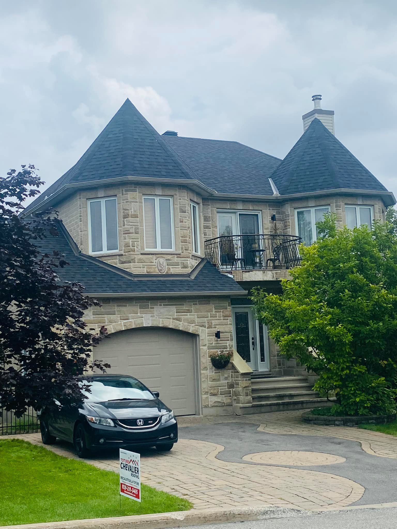 Une grande maison avec une voiture garée devant.