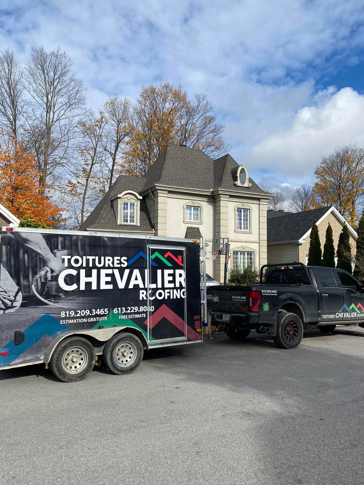Un camion et une remorque sont garés devant une maison.