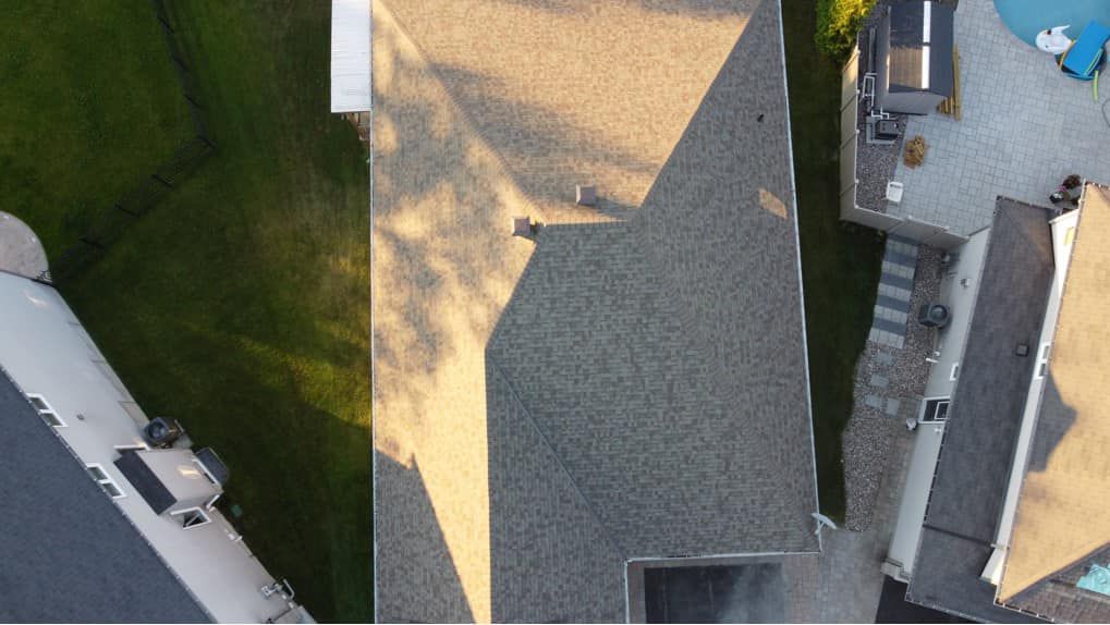 Une vue aérienne d'une maison avec un toit et une piscine.