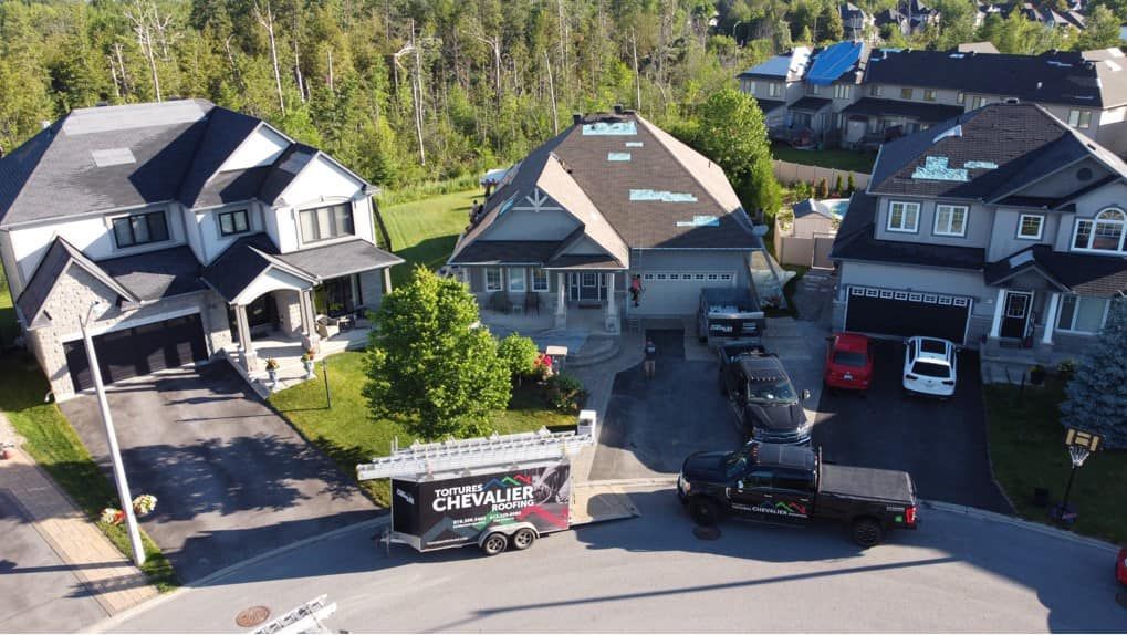 Une vue aérienne d'un quartier résidentiel avec des voitures garées devant les maisons.