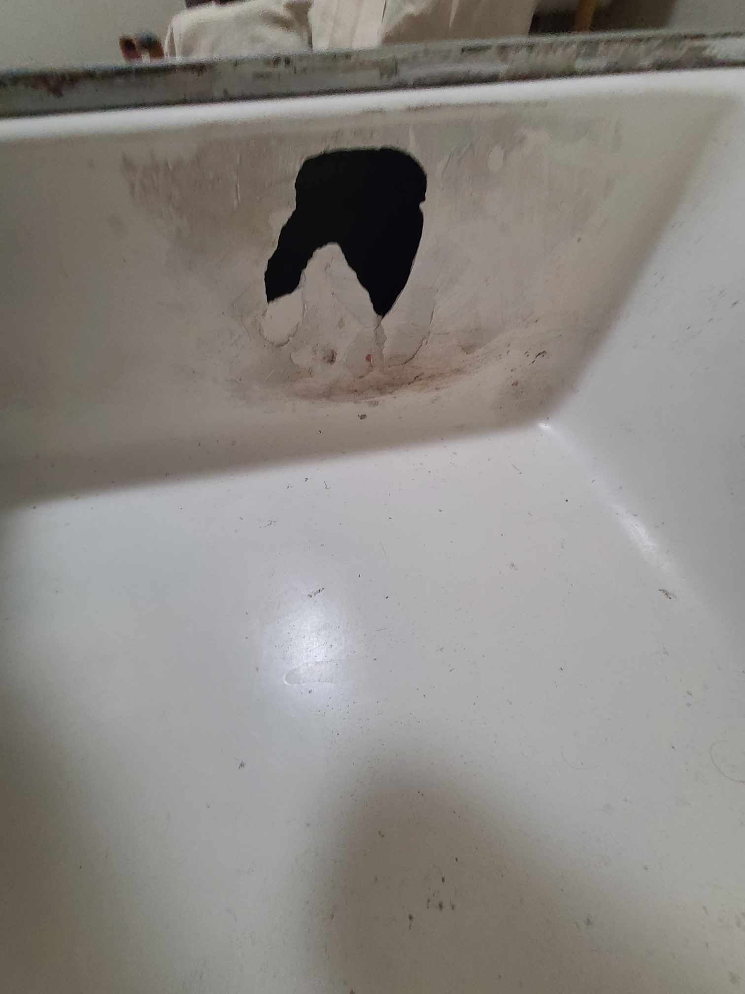 Image of a shower pan that has a hole in it. 