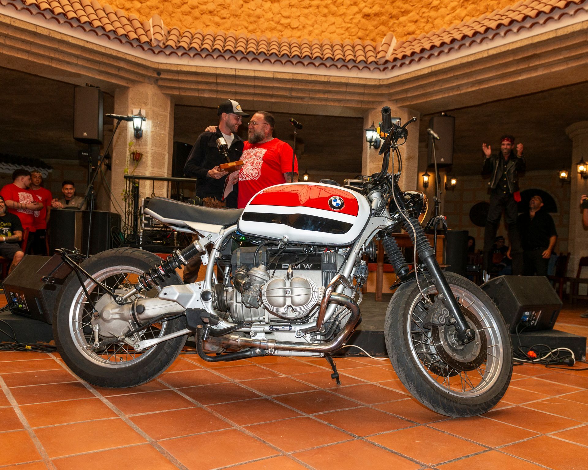 A red white and black motorcycle is parked on a tiled floor