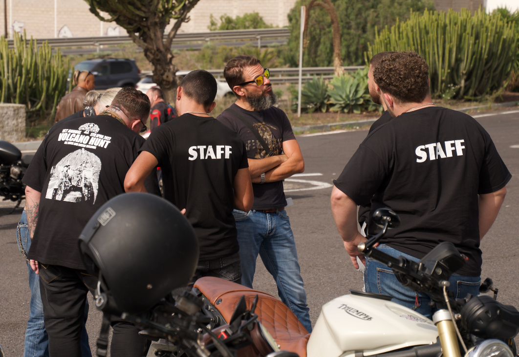 A group of men wearing black shirts that say staff