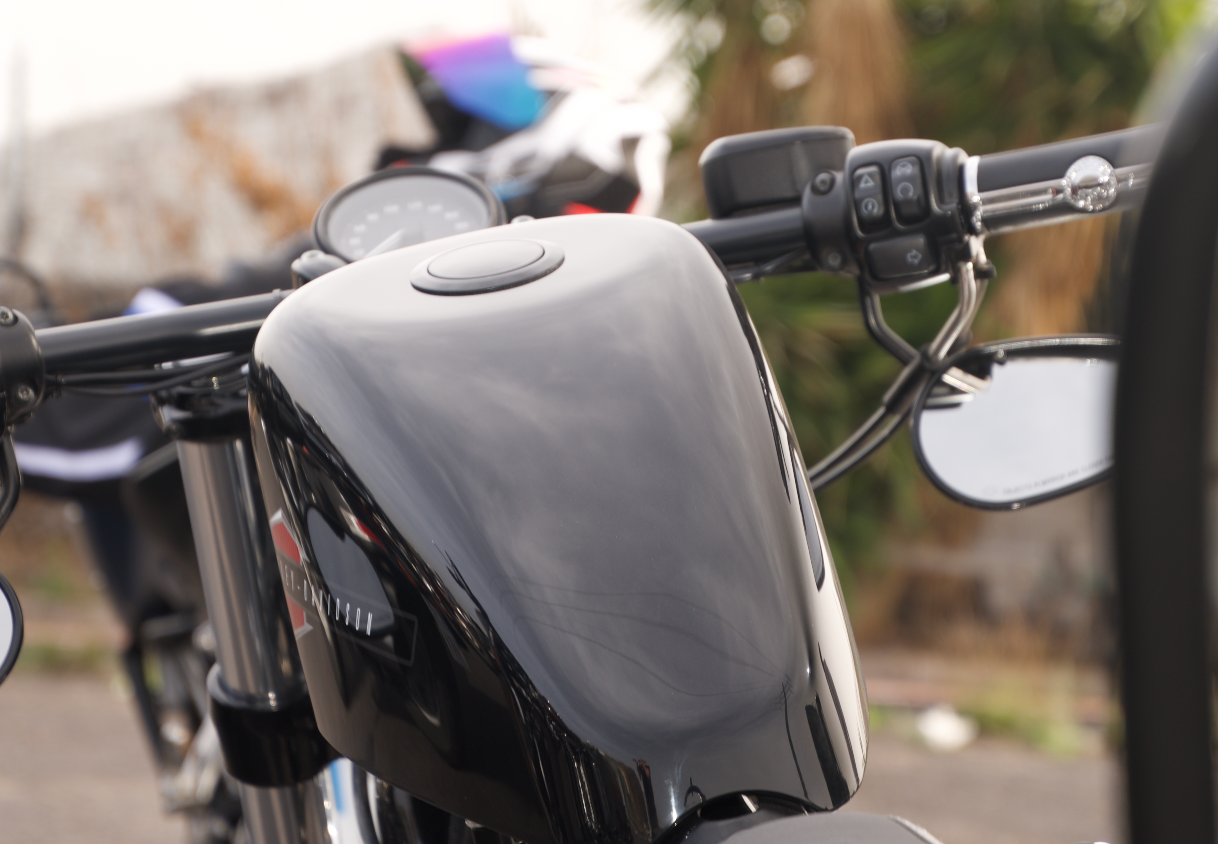 A close up of a motorcycle 's handlebars and gas tank
