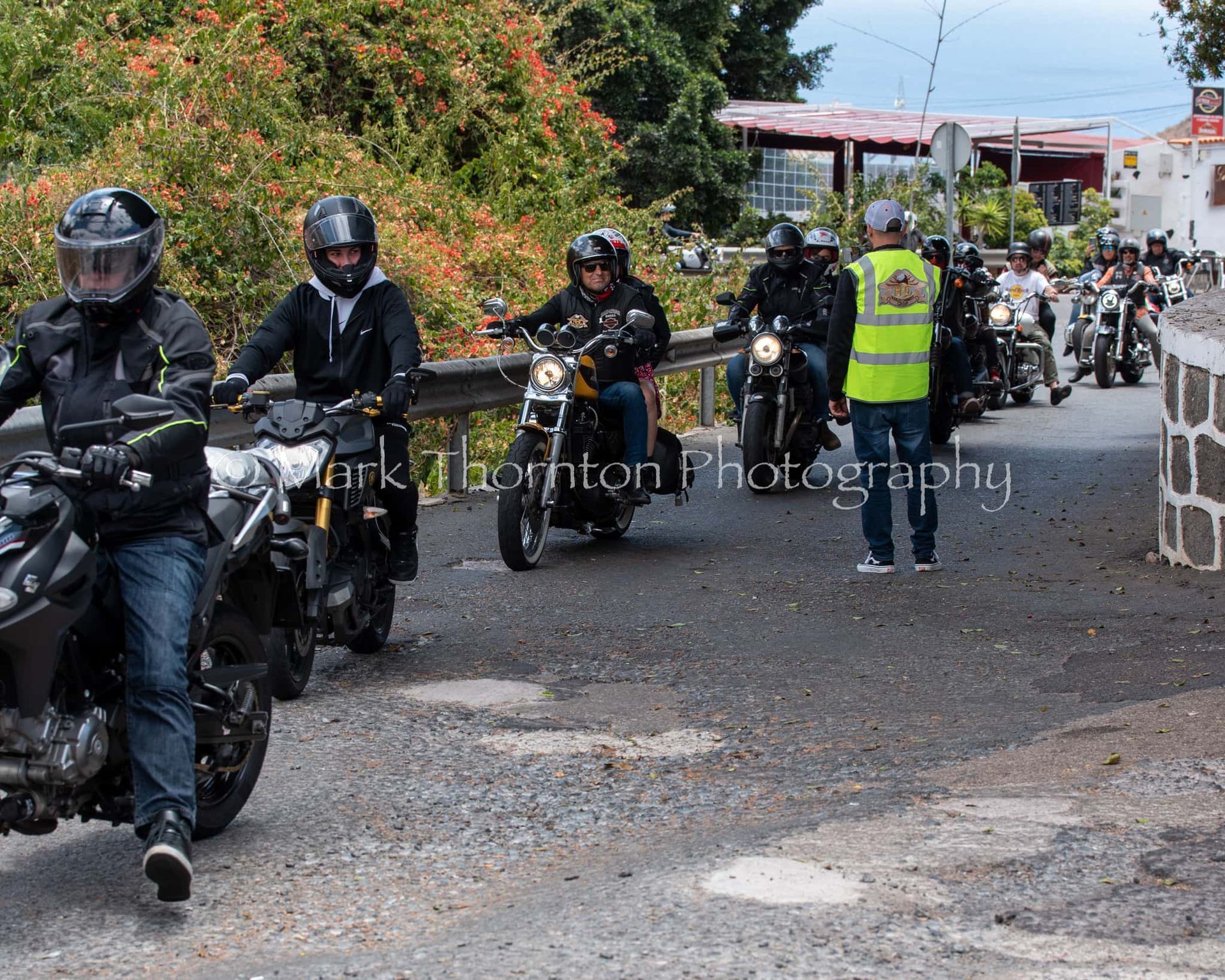 A group of people are riding motorcycles down a road
