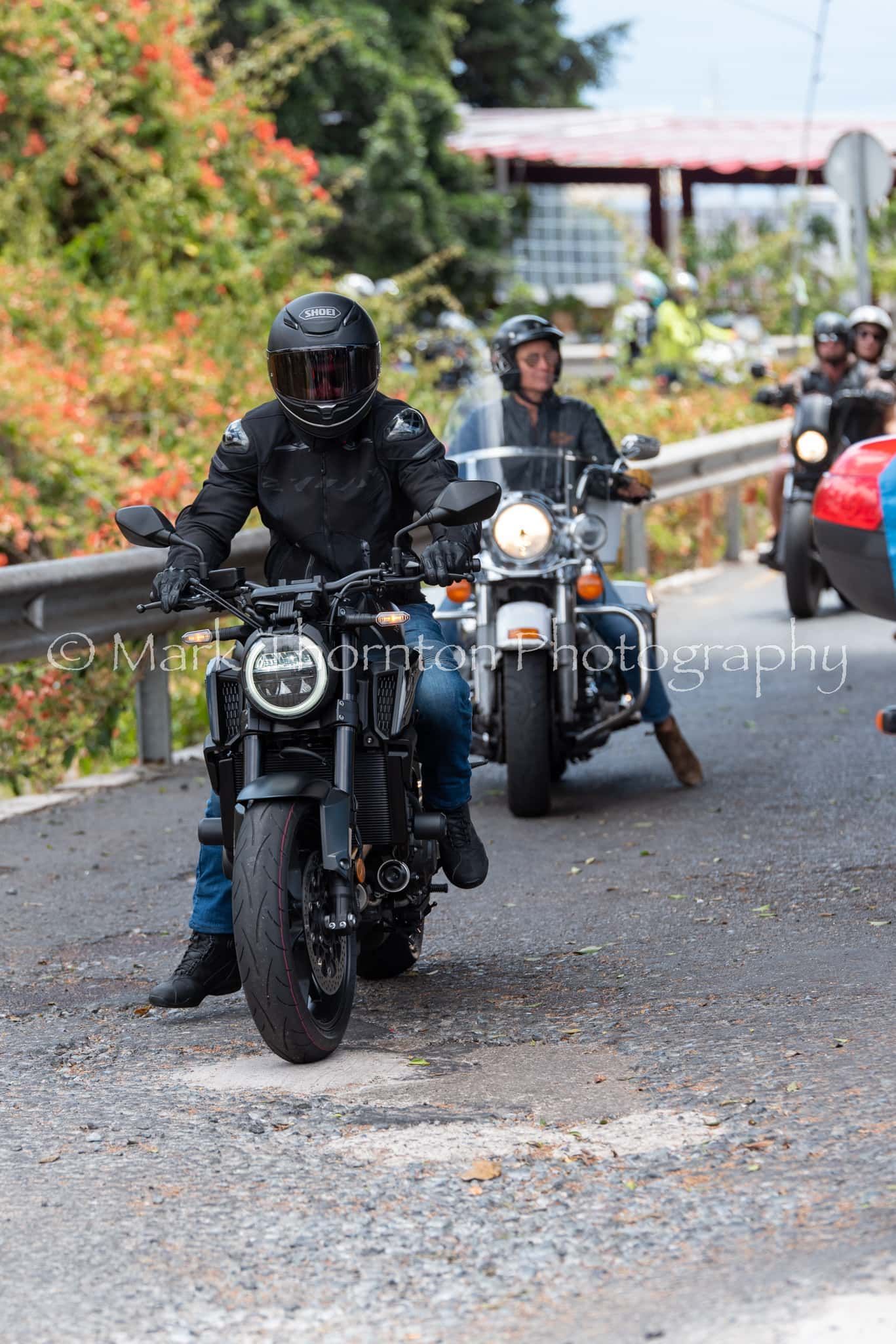 A group of people are riding motorcycles down a road.