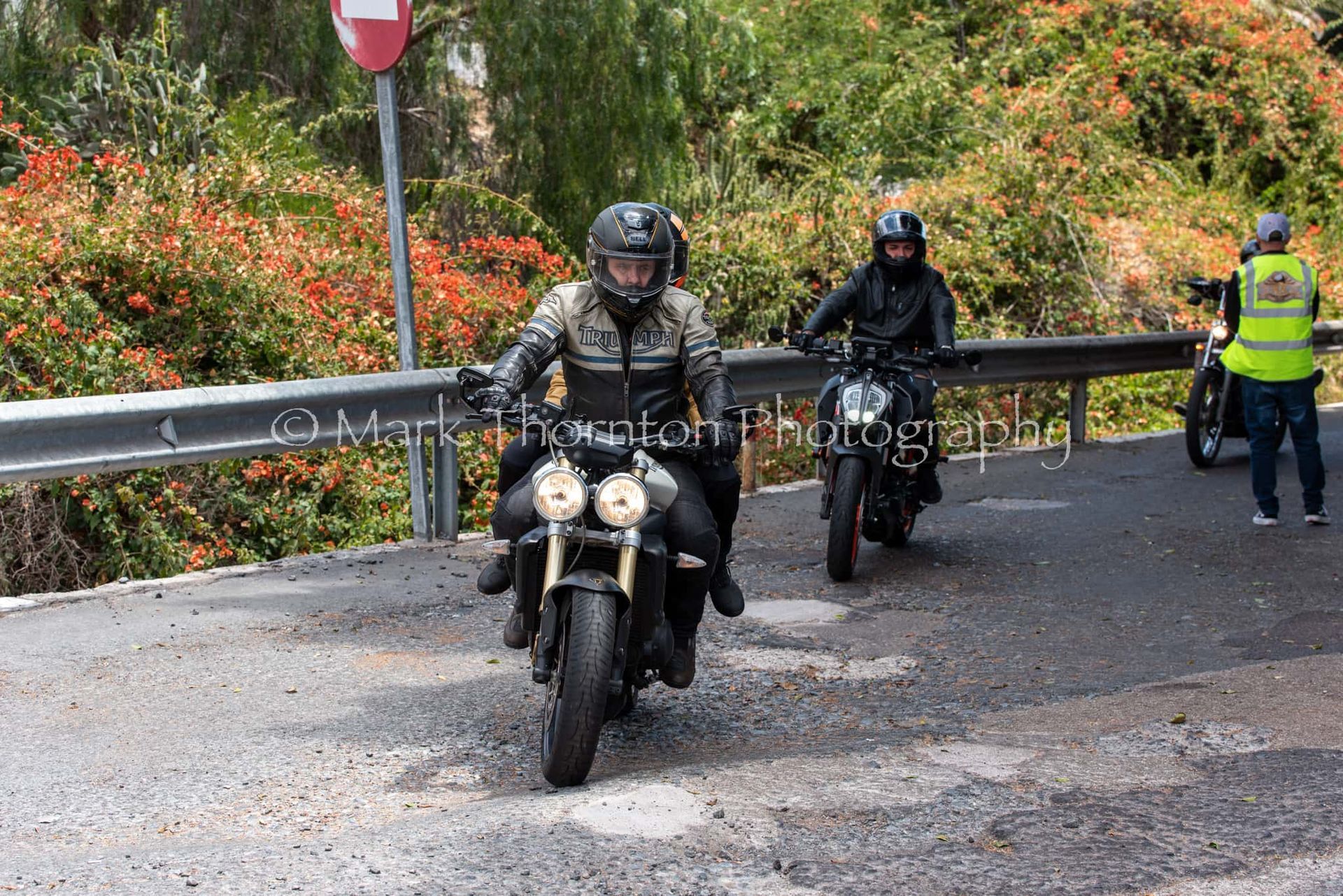 A group of people riding motorcycles down a road