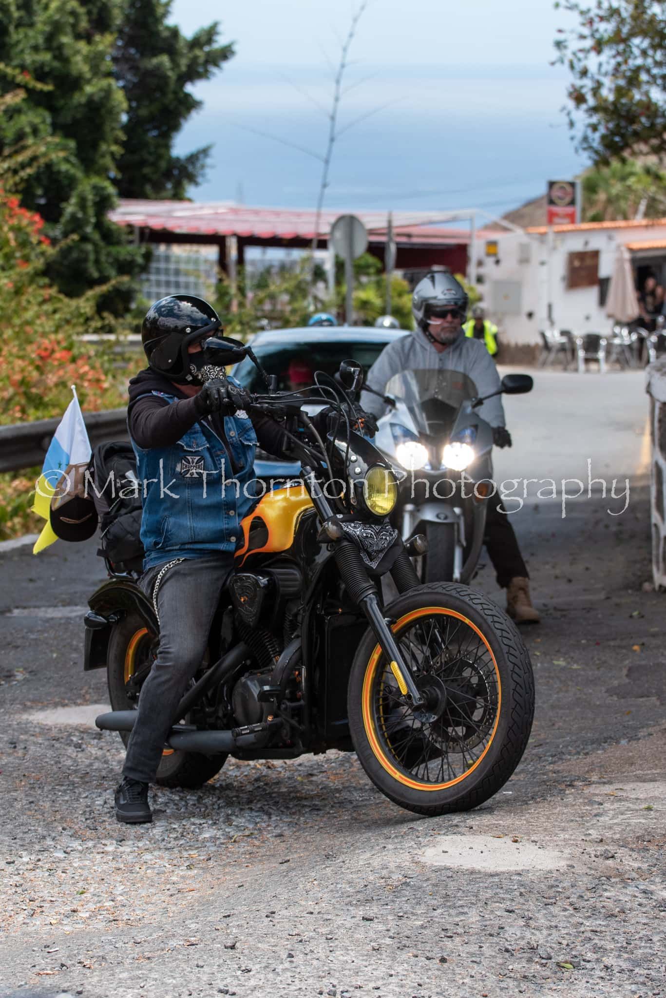 A man is riding a motorcycle next to another man on a sidecar.