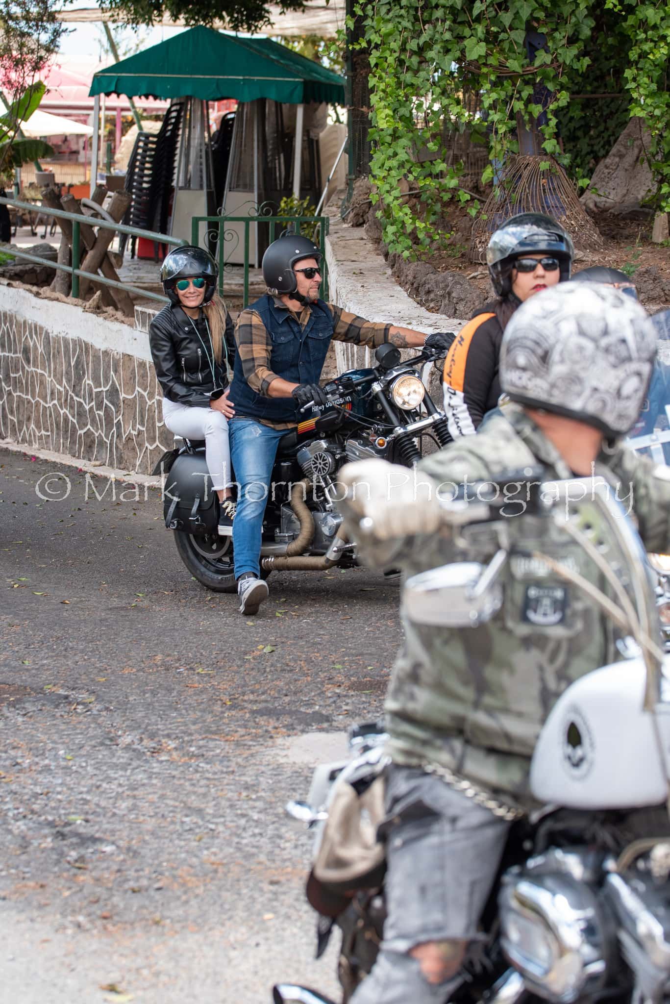 A group of people are riding motorcycles down a street.