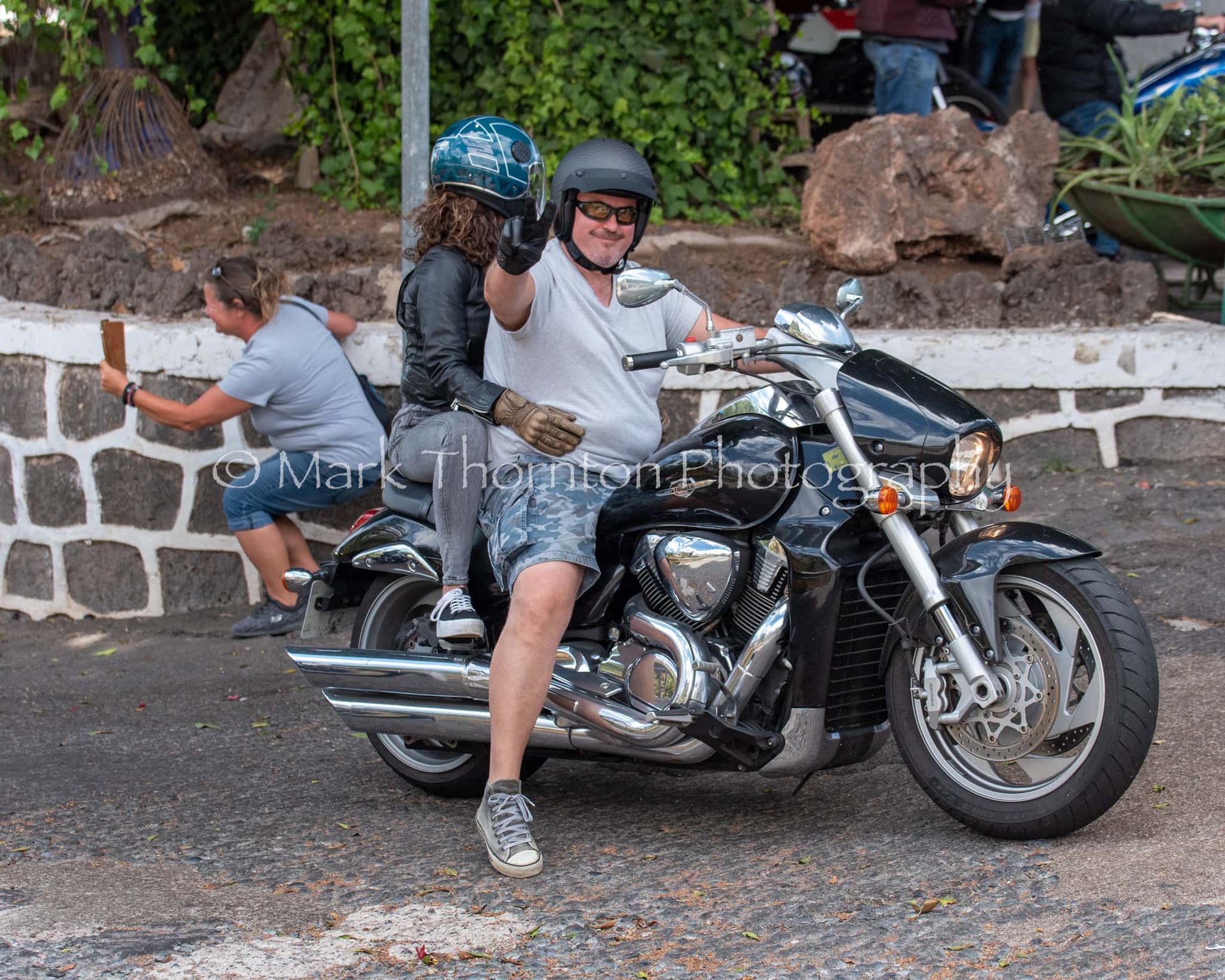 A man is riding a motorcycle with a woman on the back