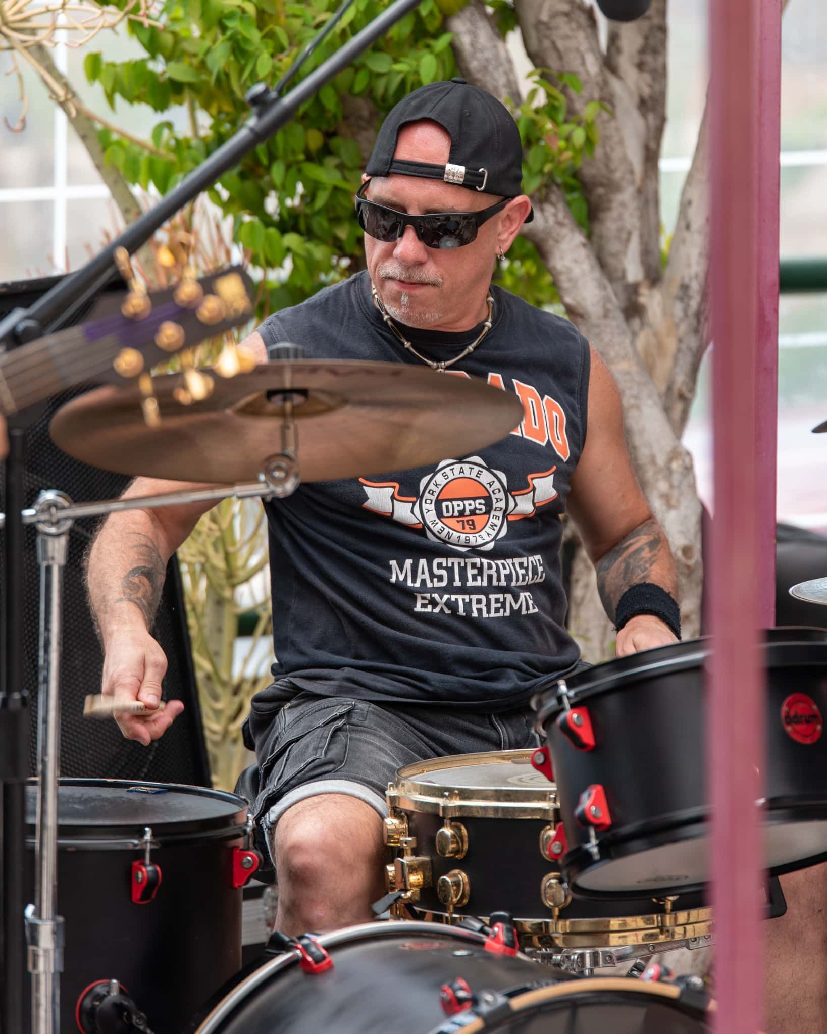 A man in a black shirt is playing drums
