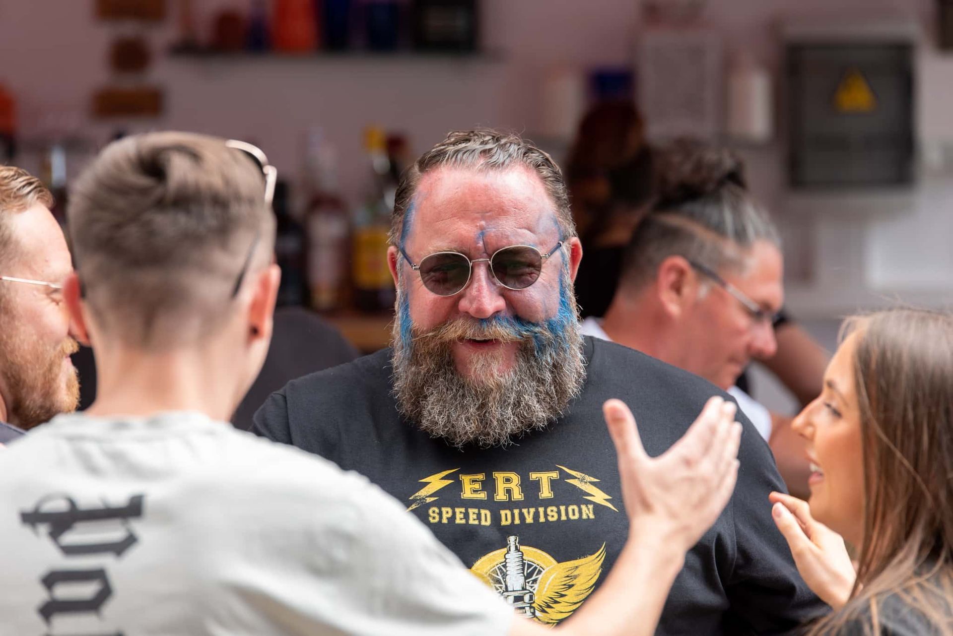 A man with a beard and mustache is talking to a group of people.
